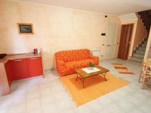 un soggiorno con divano arancione e tavolo di Holiday Home Is Molas by Interhome a Santa Margherita di Pula