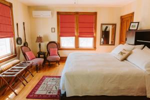 a bedroom with a large white bed and two chairs at Alicion Bed & Breakfast in Lunenburg