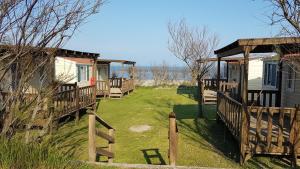 a home with a deck and a house at Camping Ancora in Comacchio