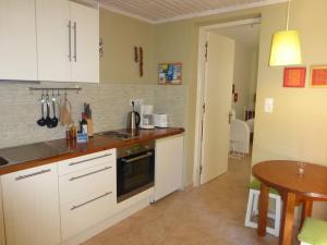 a kitchen with white cabinets and a table in it at Aperi View in Karpathos