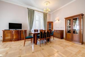 a dining room with a table and chairs and a television at DR Apartments - Kos in Sopot