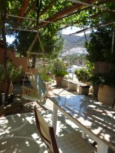 a patio with chairs and a table and a swing at Aperi View in Karpathos