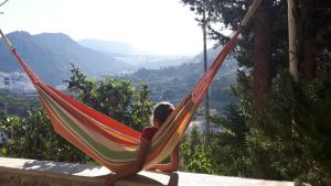 a person sitting in a hammock overlooking a valley at Aperi View in Karpathos