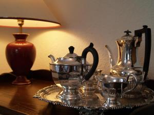 a table with a tea set on a table with a lamp at Cornlee in Aysgarth