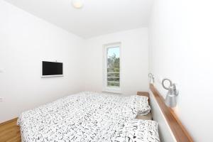 biała sypialnia z łóżkiem i oknem w obiekcie Apartments Vila Moli w Bibinje