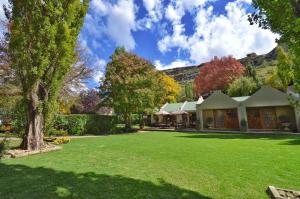 a house with a green yard with trees at Zwartmodder Clarens in Clarens
