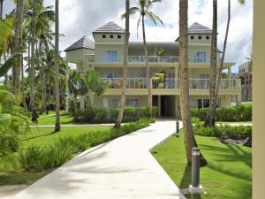 a large building with palm trees in front of it at Coson Bay in Las Terrenas