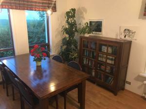 Selalækur Country Guesthouse في هيلاّ: غرفة طعام مع طاولة ورف كتاب