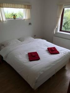 a white bed with two red towels on it at Selalækur Country Guesthouse in Hella