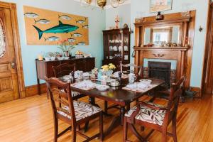 une salle à manger avec une table, des chaises et un tableau de poisson dans l'établissement Alicion Bed & Breakfast, à Lunenburg