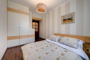 a bedroom with a large bed with a wooden headboard at DR Apartments - Patio Mare in Sopot