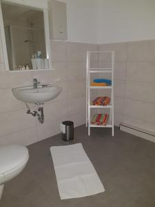 a white bathroom with a sink and a toilet at Hüschelrath gemütlich Natur in Leichlingen