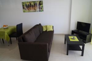 a living room with a brown couch and a table at Cittazen Aix-en-Provence - Entre gare TGV et centre ville, calme et confort moderne in Aix-en-Provence