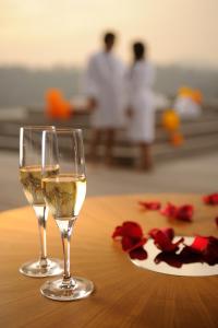 two glasses of white wine and a plate of roses at NOI Vitacura in Santiago