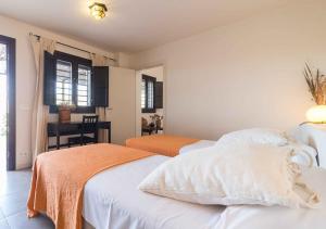 1 dormitorio con 2 camas y mesa con silla en Cortijo La Tenada Cabo de Gata en Los Albaricoques