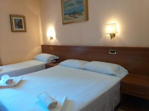 Postel nebo postele na pokoji v ubytování Hotel Aristotele