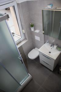 een badkamer met een wastafel, een toilet en een spiegel bij Deluxe Apartments Zagreb in Zagreb