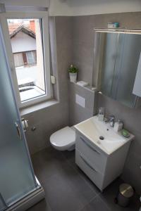 een badkamer met een wastafel en een toilet en een raam bij Deluxe Apartments Zagreb in Zagreb +35 foto's