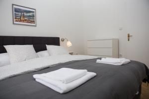 twee witte handdoeken bovenop een bed bij Deluxe Apartments Zagreb in Zagreb