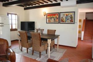 a dining room with a black table and chairs at Il Riccio-casale panoramico con piscina in Versilia in Massarosa