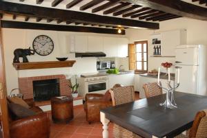 a kitchen with a fireplace and a table and chairs at Il Riccio-casale panoramico con piscina in Versilia in Massarosa