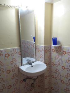 a bathroom with a sink and a mirror at Villa Corrales Homestay in Mambajao