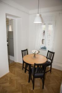 een eettafel met 2 stoelen en een vaas met bloemen bij Deluxe Apartments Zagreb in Zagreb
