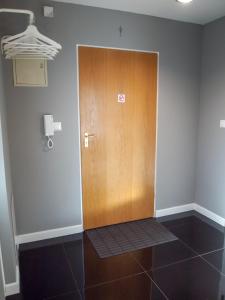 a wooden door in a room with a tile floor at MSC Apartments Gościnny in Zakopane