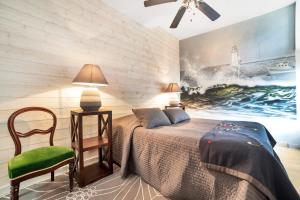 Un dormitorio con una cama y una silla y un cuadro. en Gîtes Saint Aubin, en Erquy