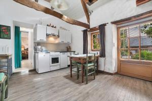 a kitchen with white appliances and a wooden floor at Gîtes Saint Aubin in Erquy