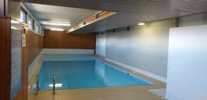 a large swimming pool in a building with a ceiling at IMMEUBLE Panorama in Les Collons