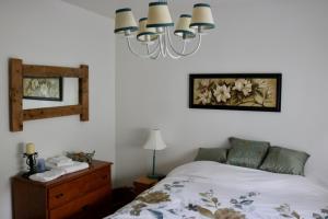 a bedroom with a bed and a chandelier at Les Petits Trésors in Coaticook