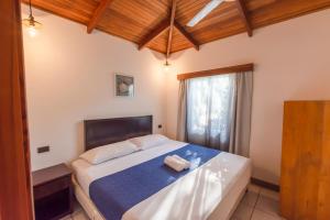 Un dormitorio con una cama grande con ventana. en Casas Santa Teresa, en Santa Teresa Beach