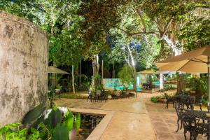 un patio con mesas, sombrillas y una piscina en Verde Morada en Valladolid