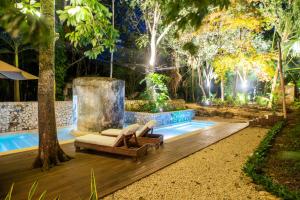een achtertuin met een zwembad met 2 stoelen en een fontein bij Verde Morada in Valladolid