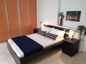 a bedroom with a bed with a blue and white comforter at Apartamento Alfaqueque in Seville