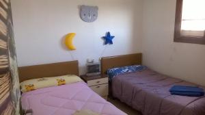 Habitación con 2 camas y reloj en la pared en Apartamento Espert en El Perelló