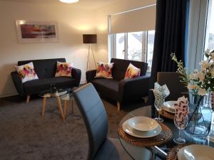a living room with two couches and a table at Carnegie Place in East Kilbride