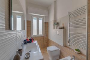 W łazience znajduje się toaleta, umywalka i lustro. w obiekcie La casetta di Lulù w mieście Nettuno