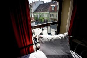 a bedroom window with a view of a city street at B13 Hostel in Sibiu