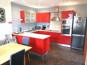 a kitchen with red cabinets and a white counter top at Casa do Vale in São Vicente