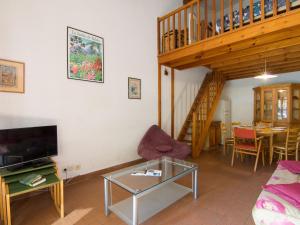 a living room with a couch a table and a staircase at Holiday Home Juncades by Interhome in Seignosse