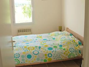 a bedroom with a bed with a polka dot bedspread at Holiday Home Lapeyriere by Interhome in Saint-Pantaléon