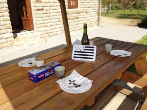 a wooden table with a bottle of wine and glasses at Holiday Home Maison Mestrezec by Interhome in Fouesnant