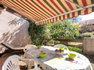 a table and chairs under an umbrella on a patio at Holiday Home Juncades by Interhome in Seignosse