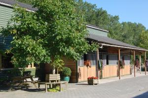 ein Gebäude mit einem Baum und Bänken davor in der Unterkunft Lelymare Logies in Lelystad