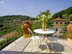 un tavolo e sedie su un balcone con vasi di Apartment Relais-1 by Interhome a San Baronto