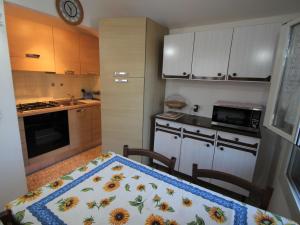 a kitchen with a table with a sunflower blanket on it at Apartment Taverna Il Cippo by Interhome in Mortola Superiore