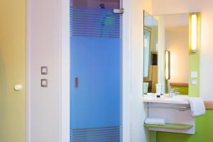 y baño con lavabo y espejo. en ibis budget Lyon Sud St Genis Laval en Saint-Genis-Laval