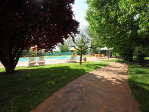 a path in a park with a pool and trees at Villa Paolotti by Interhome in Bettona